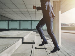 Man wearing suit runs up the stairs