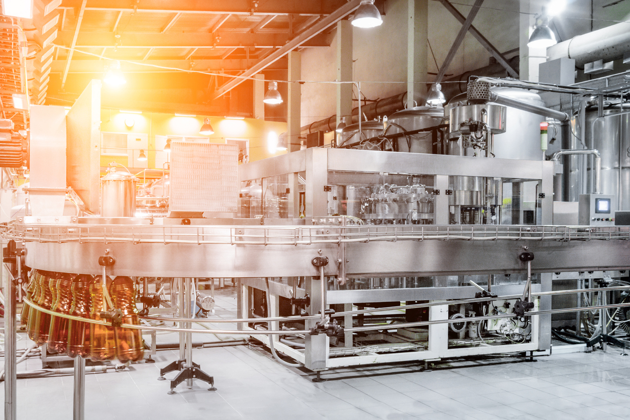 The filling machine pours beer into plastic PET bottles