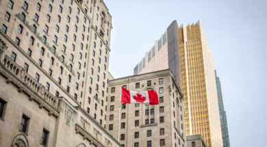 Canadian flag in front of business buildings & older skyscrapers