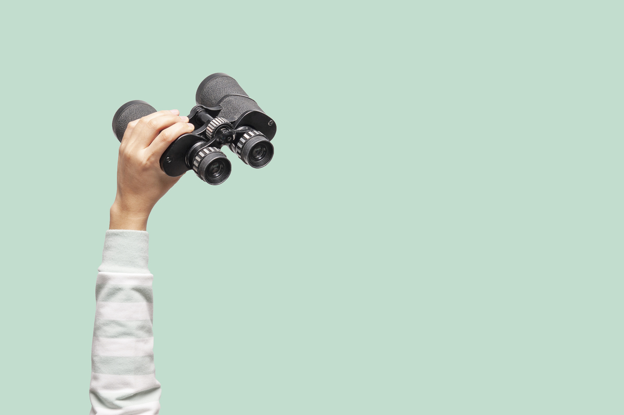 Woman with binoculars on green background