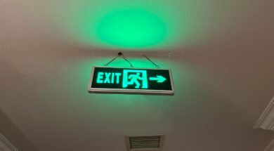 Promoting Safety and Security: Clear Green Emergency Exit Sign for Quick Evacuation in Hotel Building Corridor