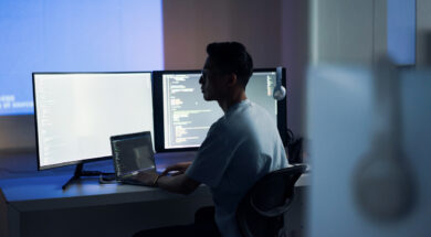 Web design, coding and Asian man with a computer for programming a website at night. Cyber security, developer and programmer reading information for a software database on a pc in a dark office