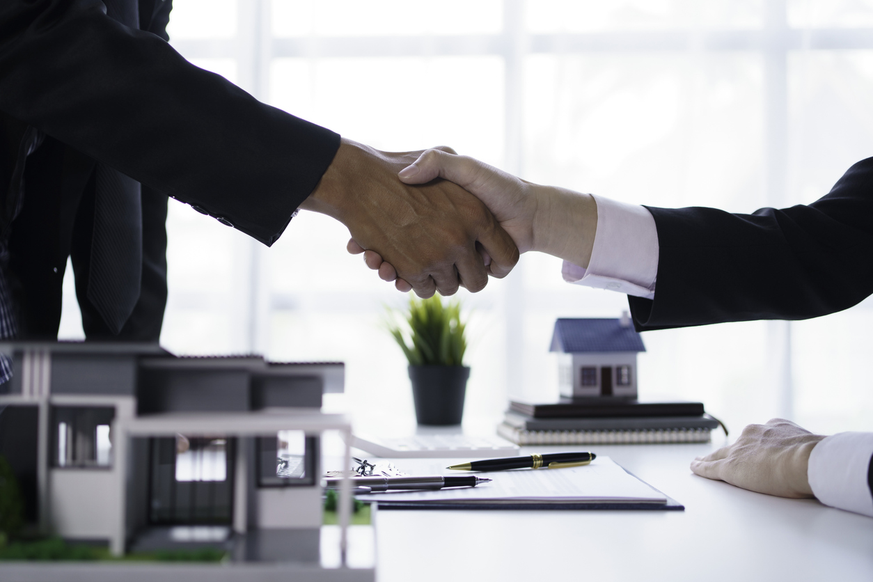 Agent and customer shake hands when successful trading houses. House and real estate trading ideas.