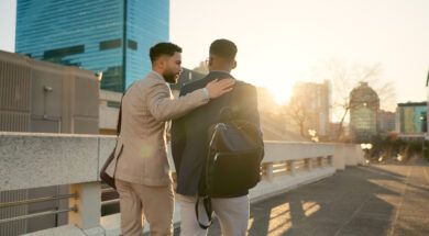 Business, men and walking in street with support in city for partnership, collaboration and teamwork. Professional, people and outdoor by buildings for travel, commute and conversation and diversity