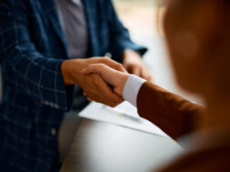 Close up of business people shaking hands in the office.