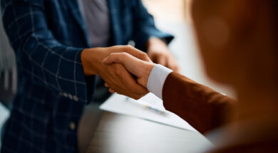 Close up of business people shaking hands in the office.