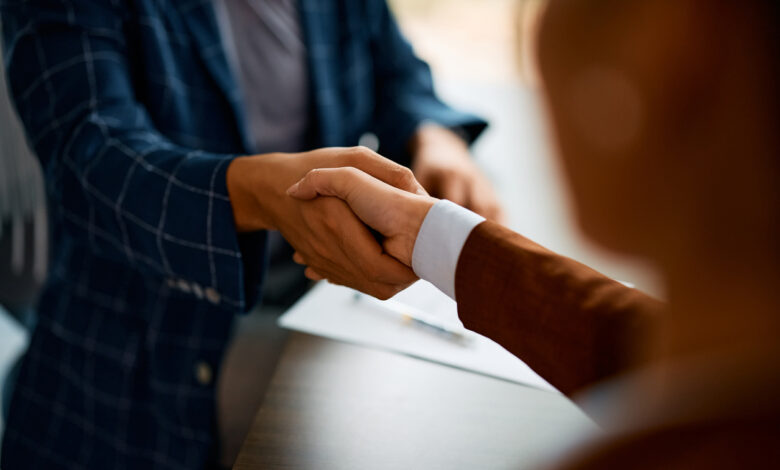 Close up of business people shaking hands in the office.