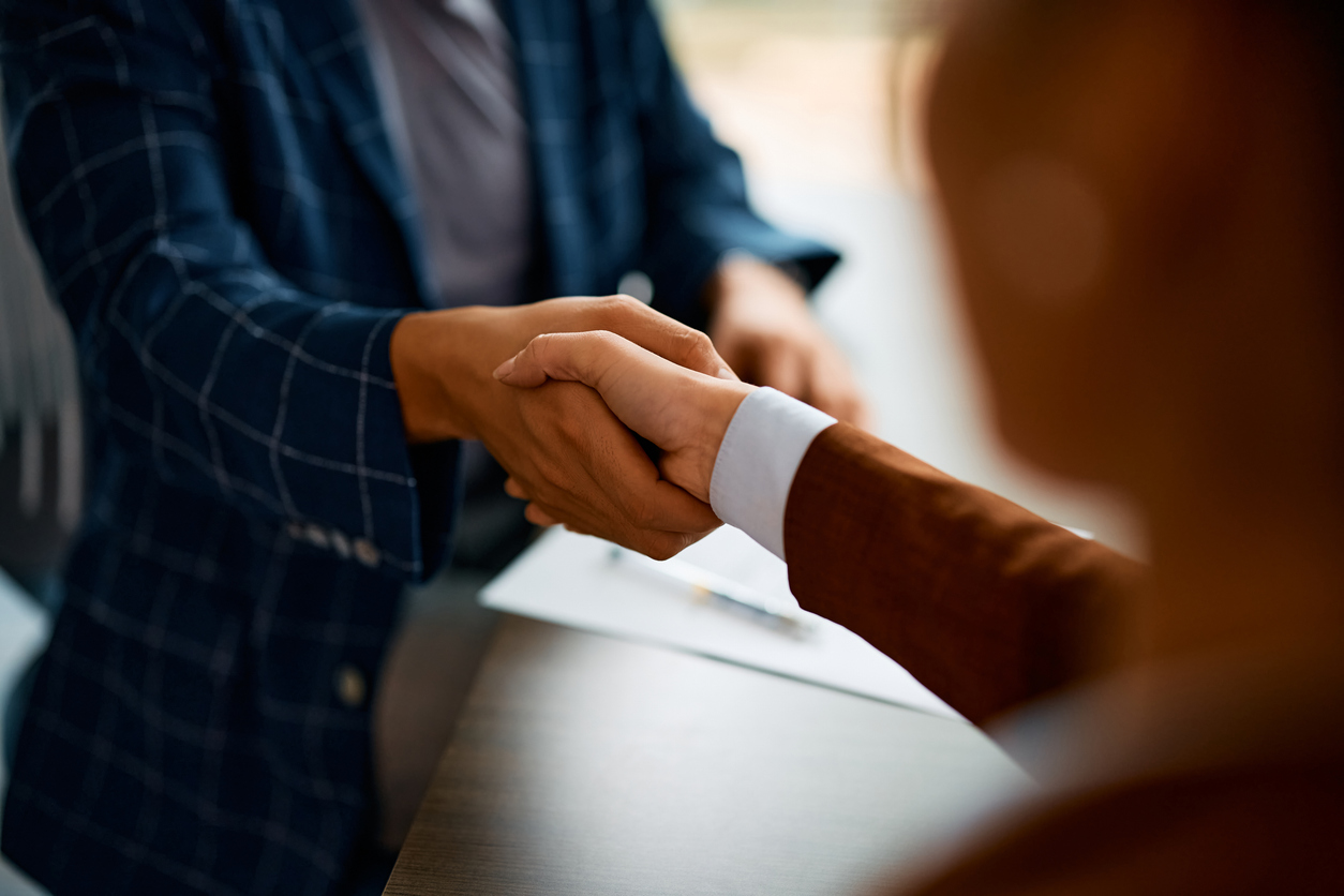 Close up of business people shaking hands in the office.