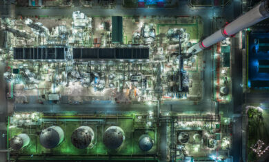 Oil refinery plant form industry zone, Aerial view oil and gas industrial, Refinery factory oil storage tank and pipeline steel at night.