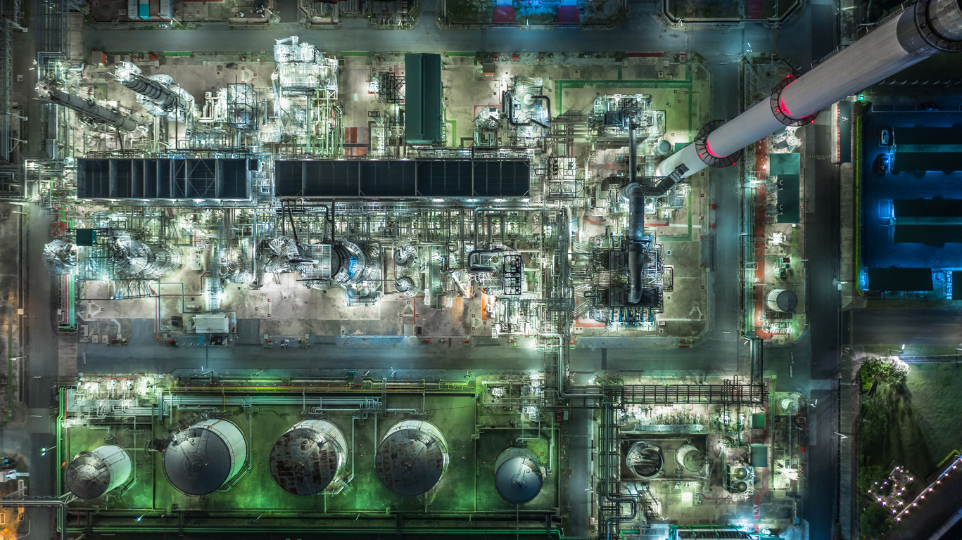 Oil refinery plant form industry zone, Aerial view oil and gas industrial, Refinery factory oil storage tank and pipeline steel at night.