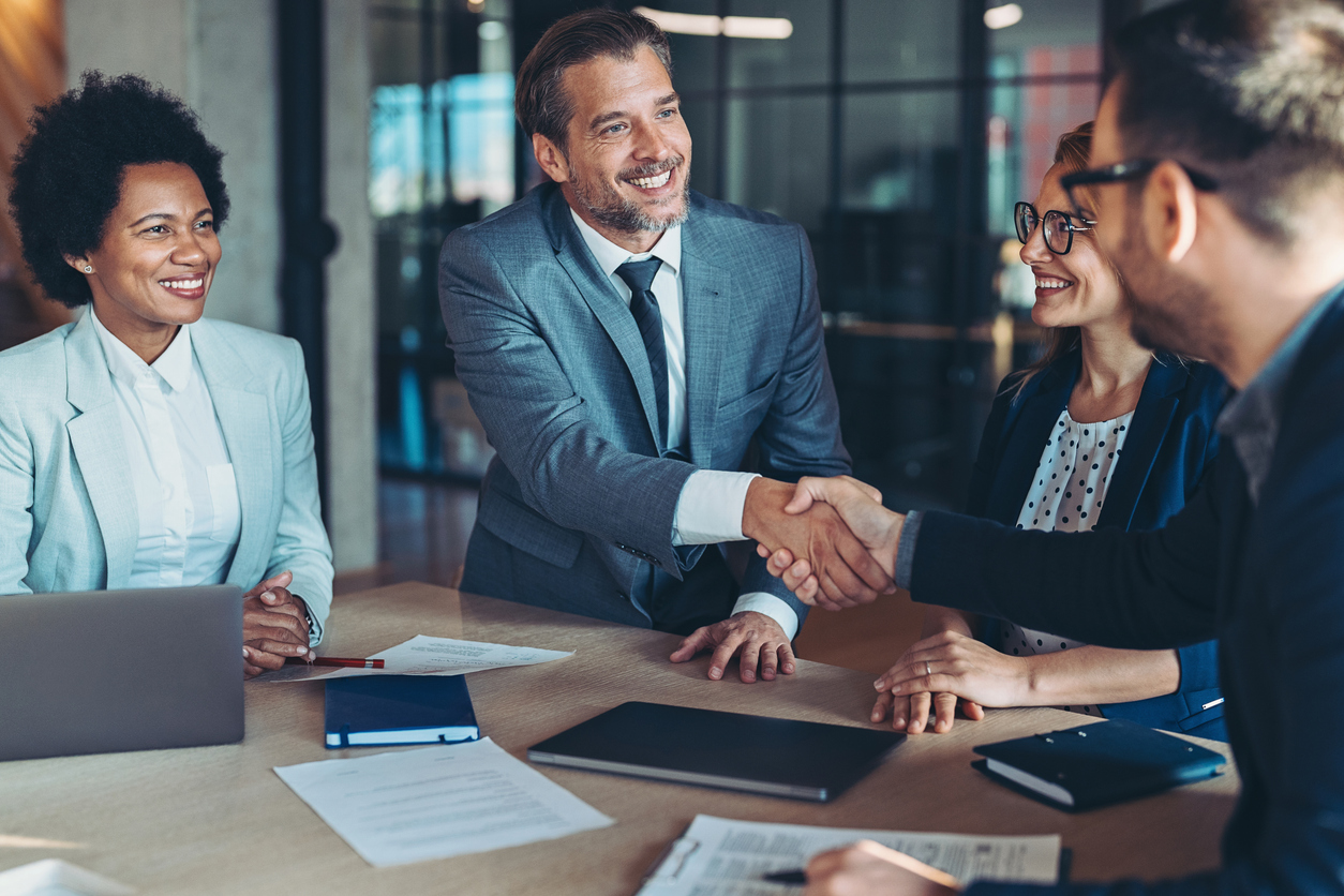 Businessmen shaking hands across the table