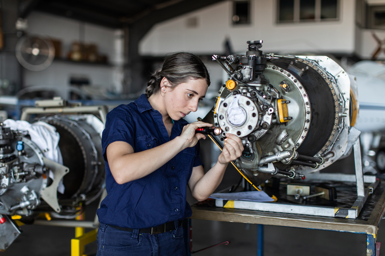 Real life young female aircraft engineer apprentice at work