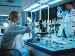 Female Medical Research Scientist Looks at Biological Samples Before Analysing it Under Digital Microscope in Applied Science Laboratory. Lab Engineer in White Coat Working on Vaccine and Medicine.