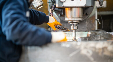 A worker in a factory working on a traditional milling machine