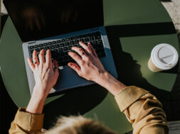 Close-up of hands typing on a laptop computer