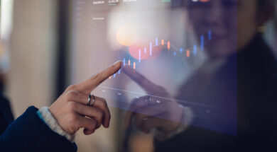 Closeup of young Asian businesswoman analysing financial data on interactive screen