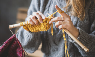 Close up on woman’s hands knitting