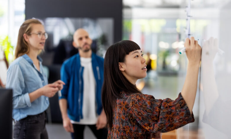 Businesswoman explaining new project plan to team in office