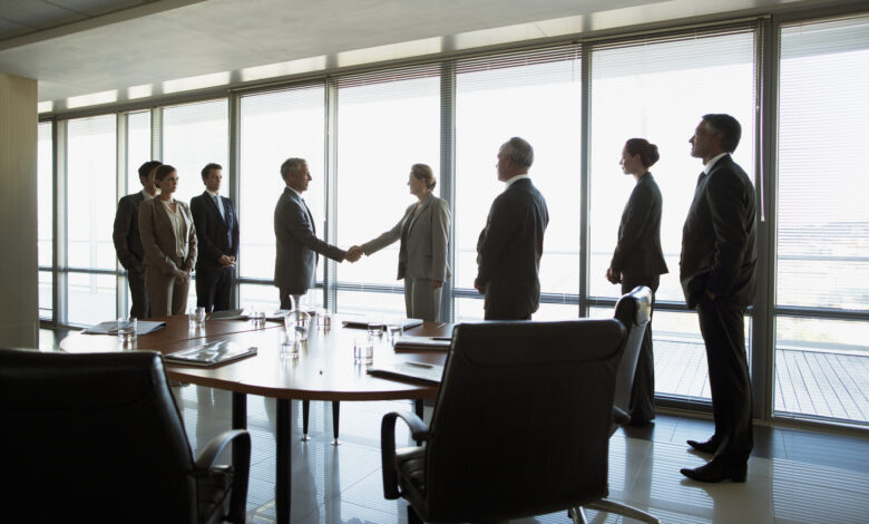 Business people shaking hands in conference room