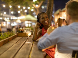 Couple drinking wine together outdoors at night