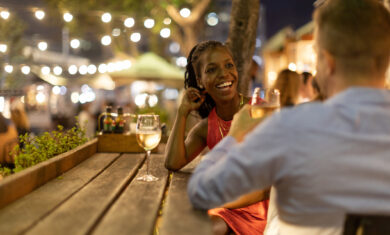 Couple drinking wine together outdoors at night