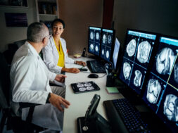 Doctors Sitting At Computer Desk Talking About Patient’s CT Scans