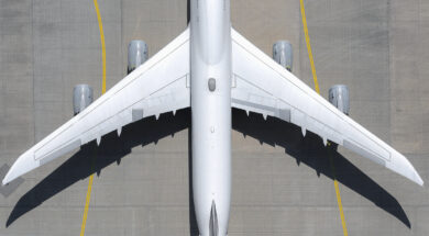 View from above white airplane on sunny airport tarmac
