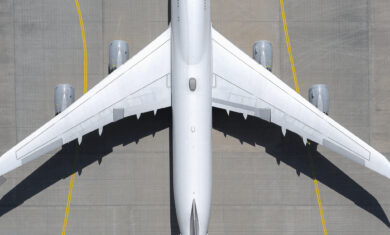 View from above white airplane on sunny airport tarmac