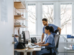 Focused male and female medical experts working on computer in clinic