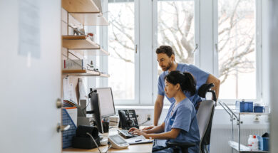 Focused male and female medical experts working on computer in clinic