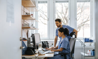 Focused male and female medical experts working on computer in clinic