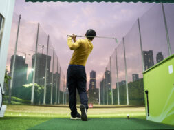 rear view of Asian man practicing golf swing