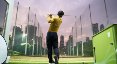 rear view of Asian man practicing golf swing