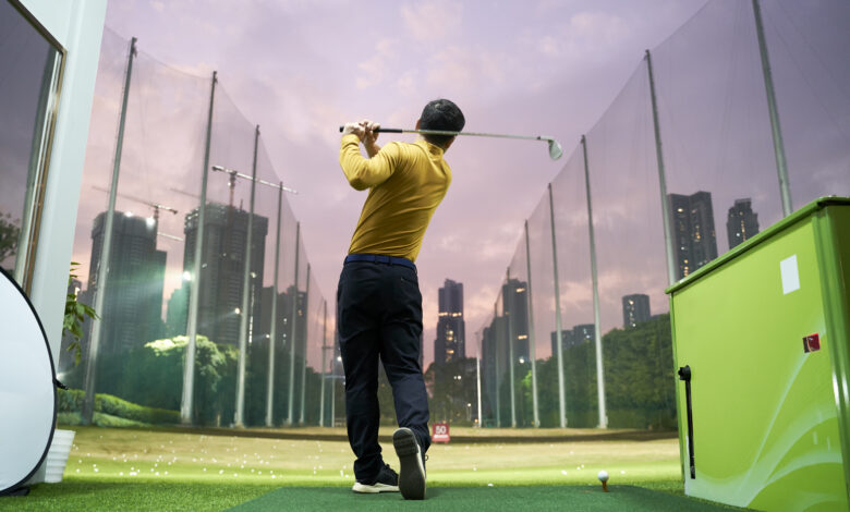 rear view of Asian man practicing golf swing