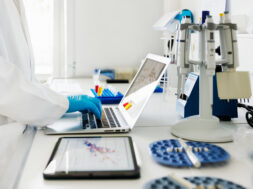 Close-Up Shot of Scientists Hands typing Data in Laptop in Laboratory