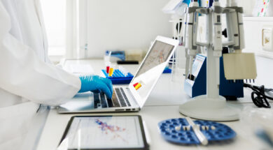 Close-Up Shot of Scientists Hands typing Data in Laptop in Laboratory