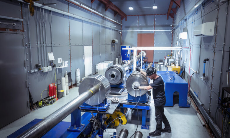 Gun technician extracting compression piston from large two stage gas gun in nuclear fusion research facility