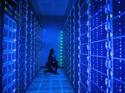 Side view of woman working in illuminated server room