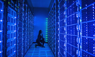 Side view of woman working in illuminated server room
