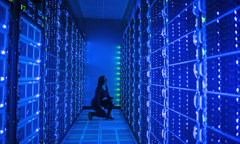 Side view of woman working in illuminated server room