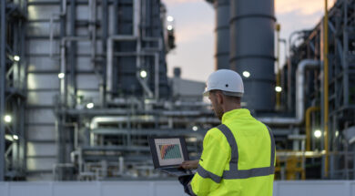 Dedicated engineer working until the late hours in the oil and gas industry with laptop.