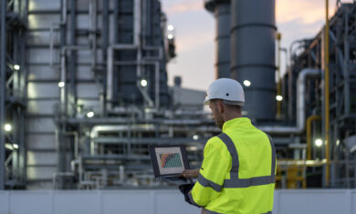 Dedicated engineer working until the late hours in the oil and gas industry with laptop.