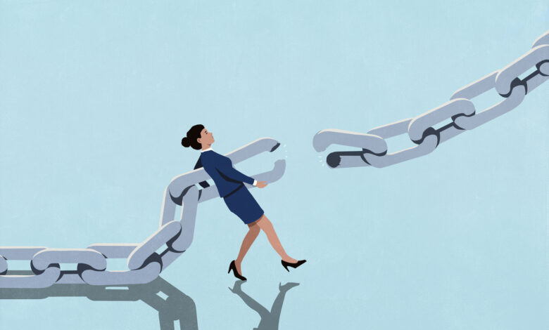 Businesswoman attempting to reconnect broken chain against blue background