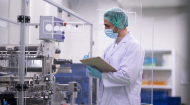 Laboratory technician inspecting pharmaceutical manufacturing in contaminate controlled room