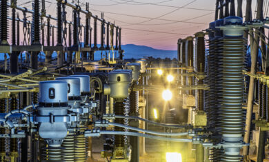 Detail of the infrastructure of an electrical substation illuminated at sunset.