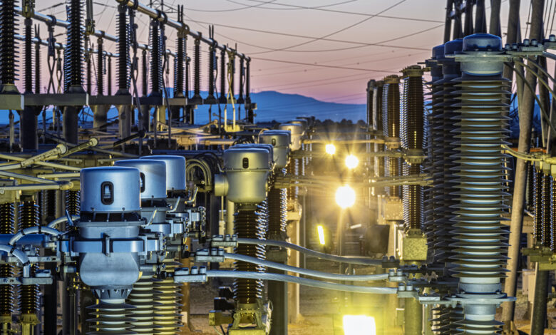 Detail of the infrastructure of an electrical substation illuminated at sunset.