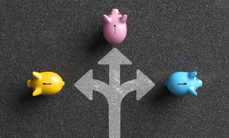 Piggy banks choosing investment path on asphalt road