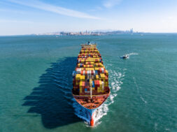 A Full Cargo Ship is Sailing in front of Qingdao City Skyline