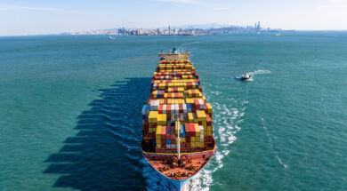 A Full Cargo Ship is Sailing in front of Qingdao City Skyline