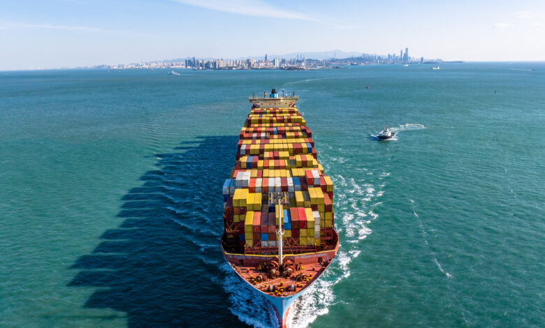 A Full Cargo Ship is Sailing in front of Qingdao City Skyline